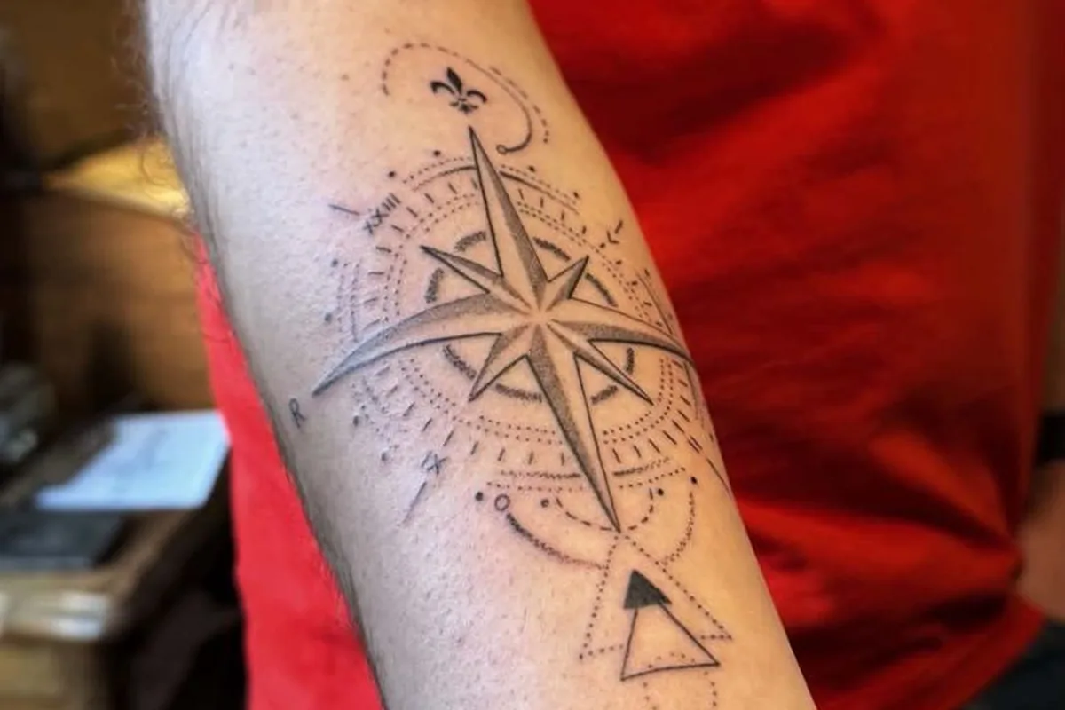 Tatouage fine line rose des vents sur l’avant-bras, réalisé par Barbe Noire Tattoo à Mouvaux